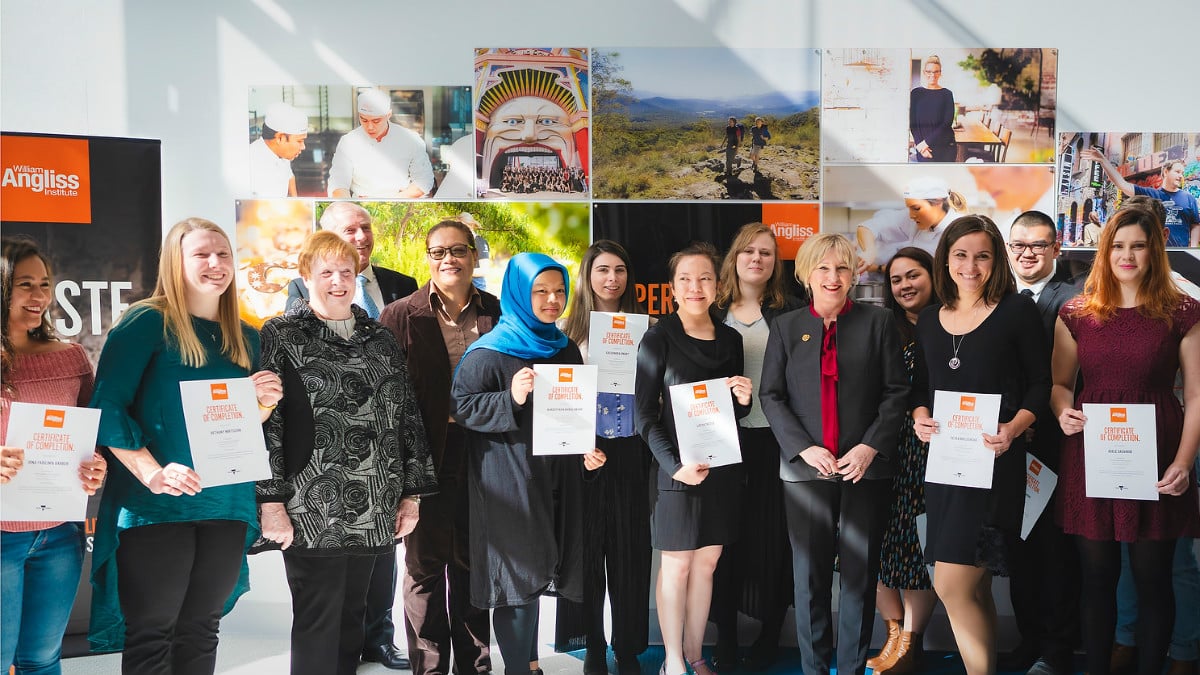 The Hon. Gayle Tierney presents an Angliss student a Certificate of Completion